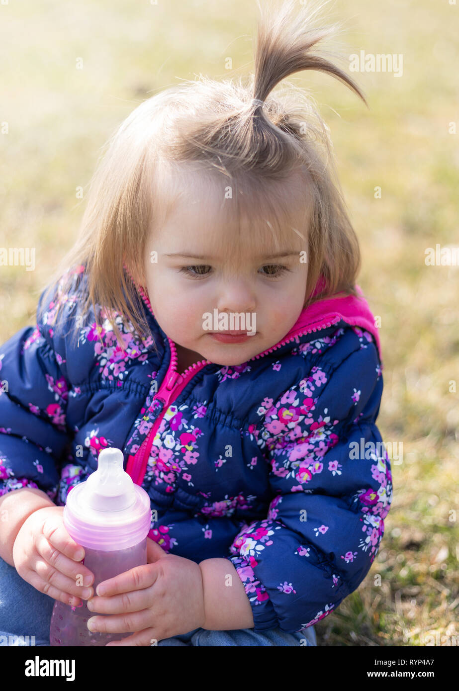 Sweet 17 Months Old Baby Girl Sitting On The Lawn And