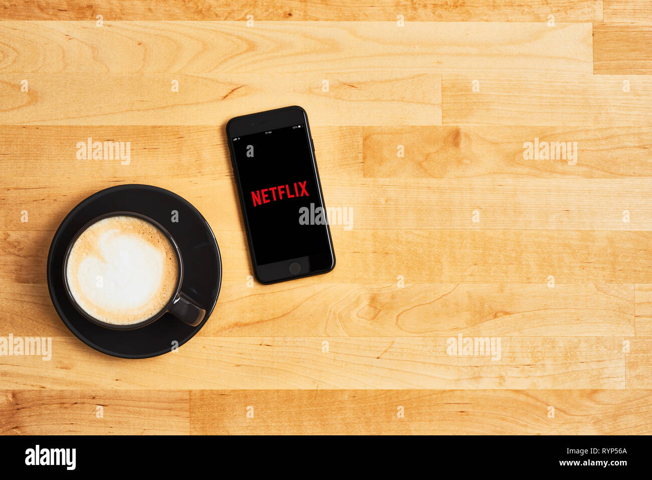 Zagreb, Croatia - March 6, 2019: Netflix logo on black Apple iPhone and  black cup of coffee or cappuccino on wooden table. Streaming movies and TV  ser Stock Photo - Alamy