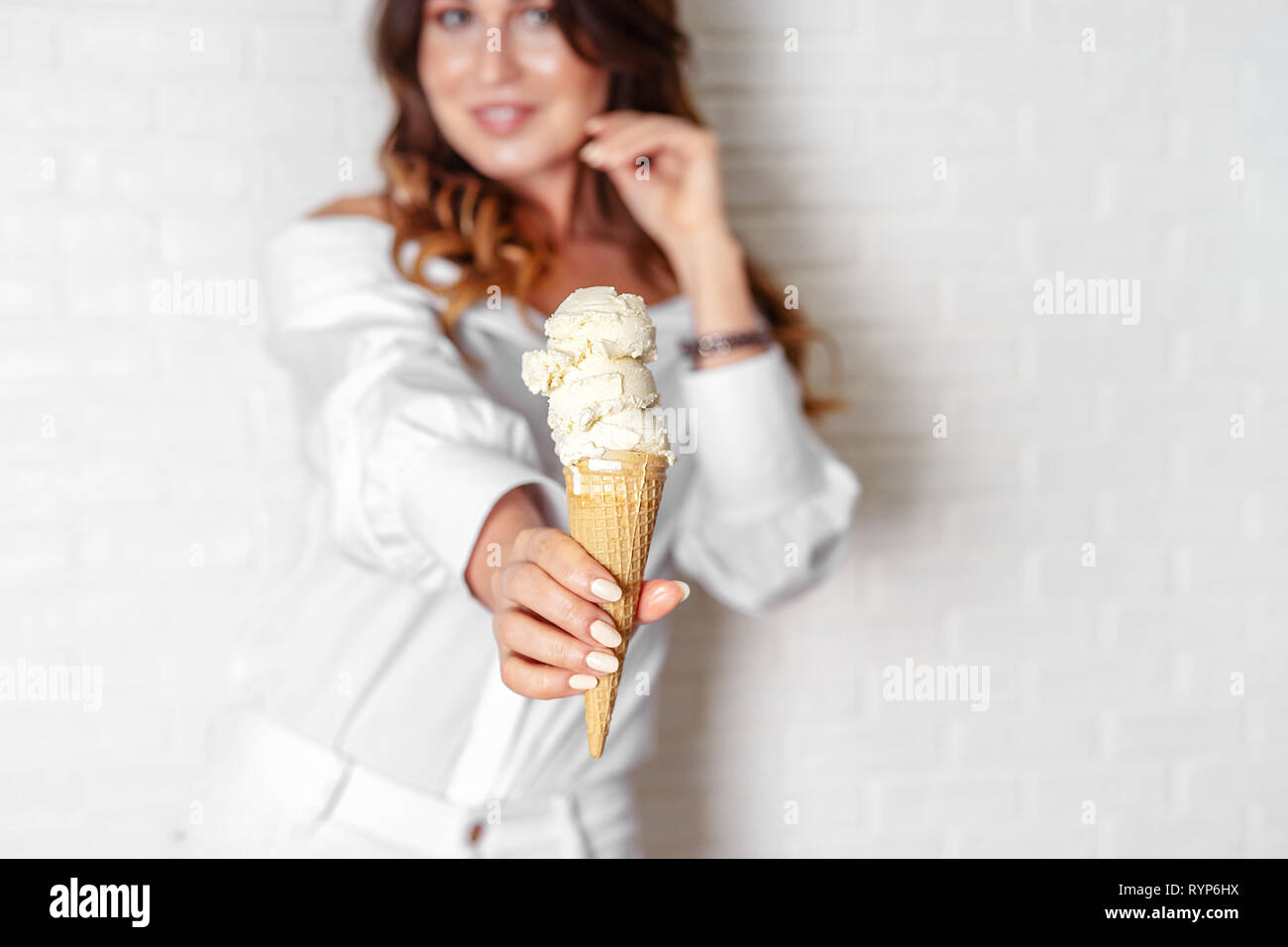 Vanilla ice cream cone in woman's hand closeup Stock Photo