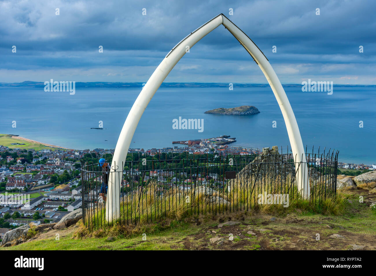 The island of Craigleith and the town of North Berwick, through replica whale bones on the summit of North Berwick Law, East Lothian, Scotland, UK Stock Photo