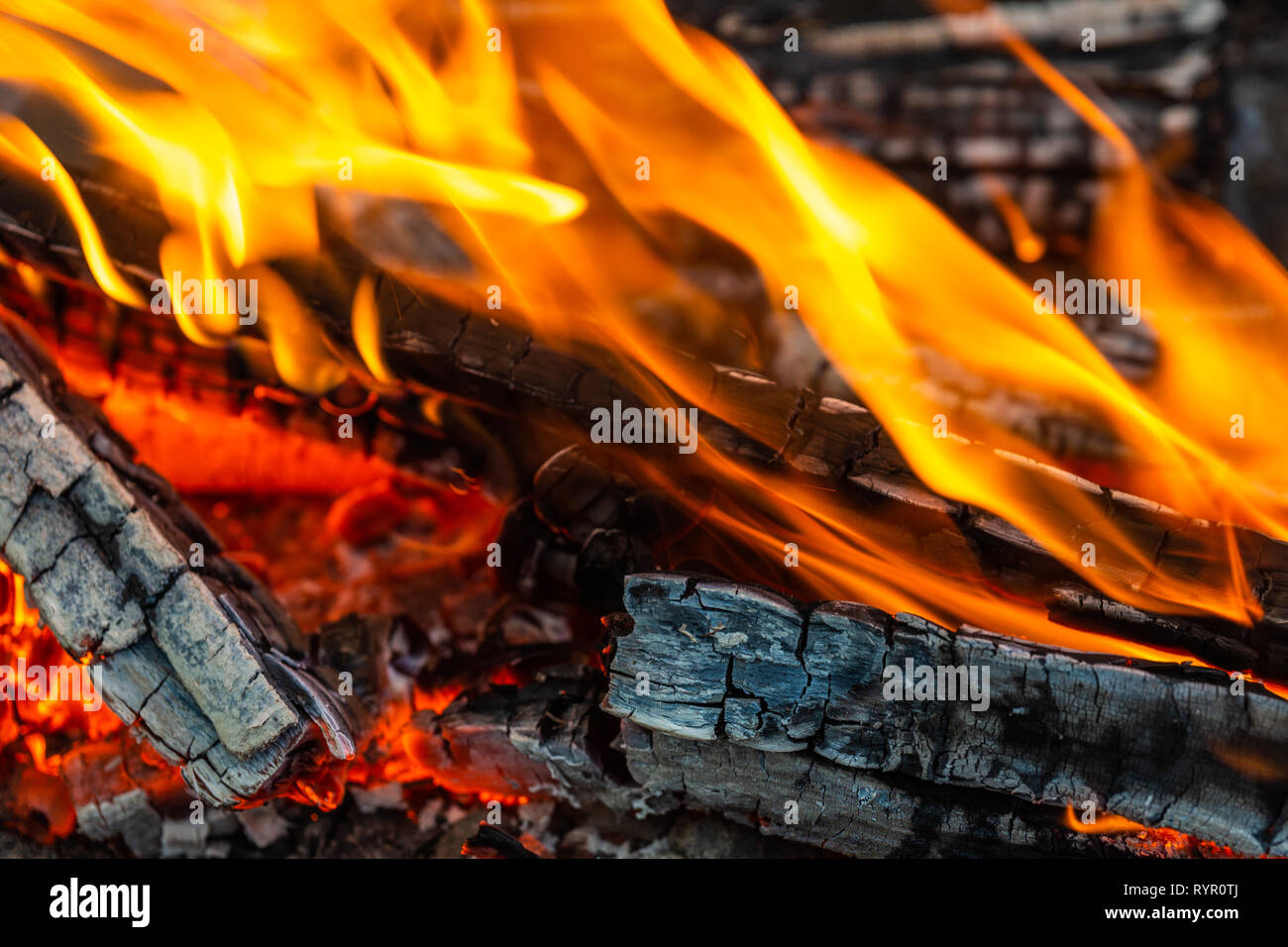 Image of burning firewood. Fire, flames, charred wood. Closeup view. Warming and cozy background or backdrop Stock Photo