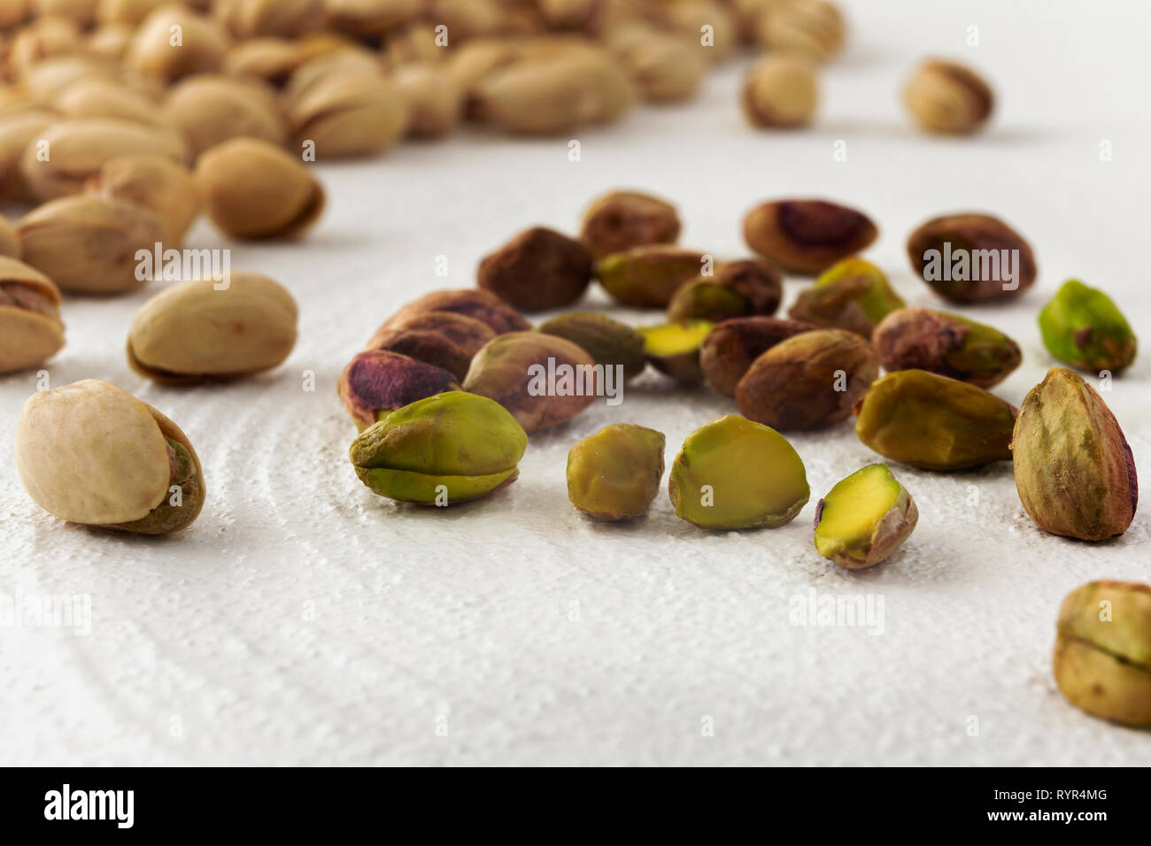 Pistachios isolated on a kitchen table, close up with white background Stock Photo