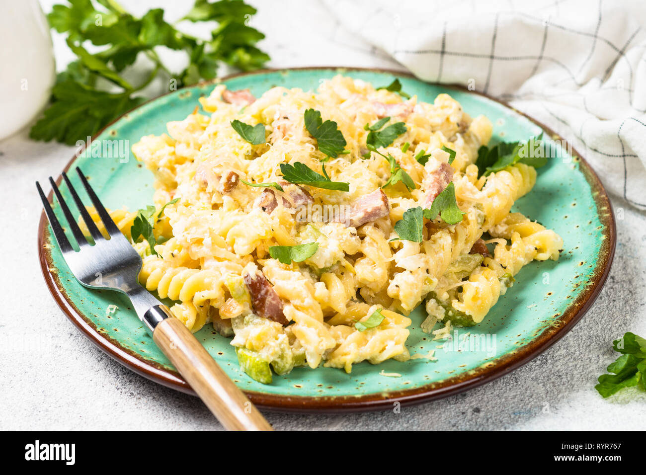 Pasta carbonara with zucchini in craft plate on white.  Stock Photo