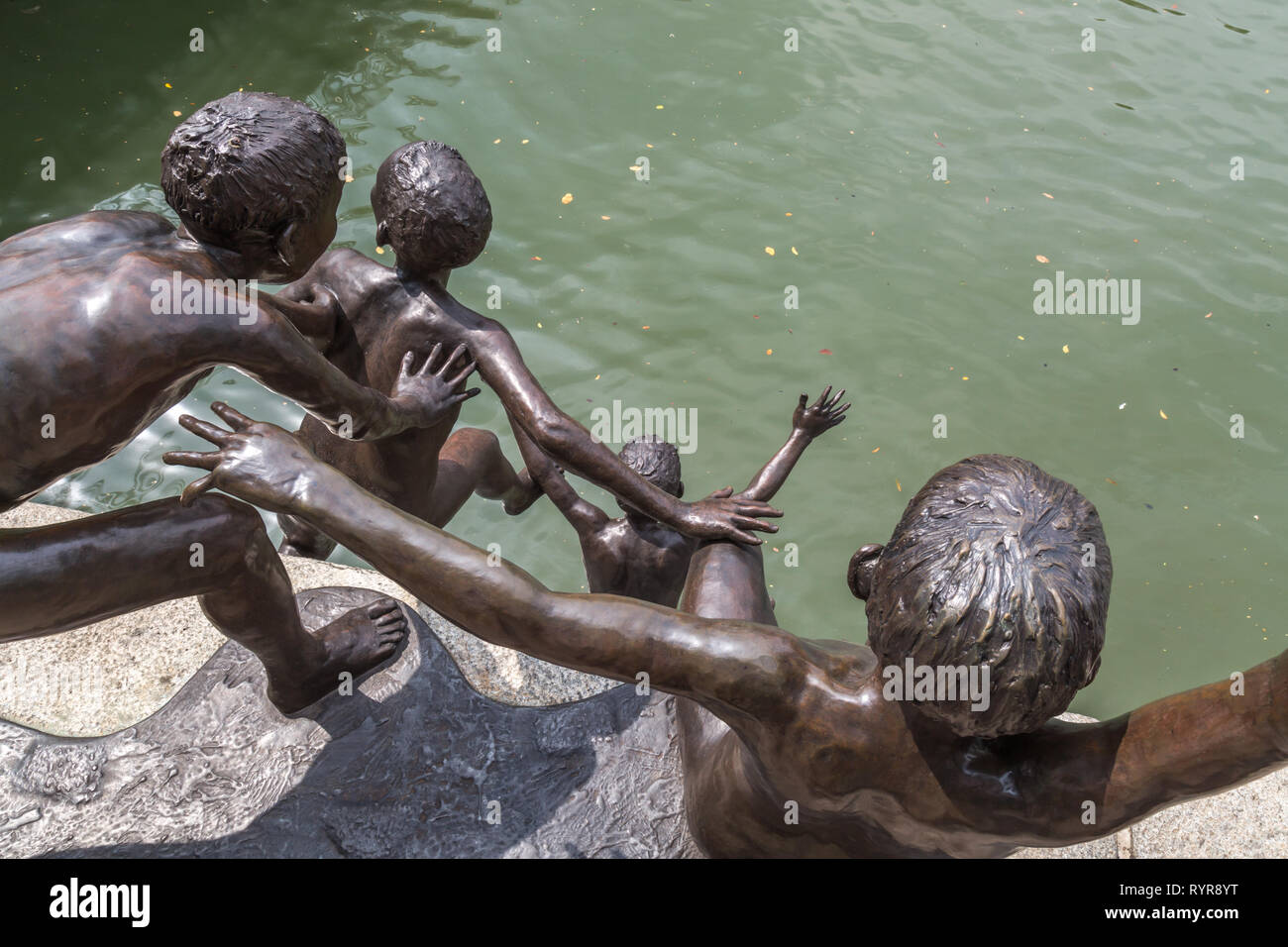 A metal sculpture of Five young boys by the river in Singapore Stock Photo