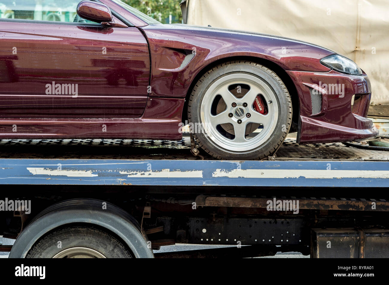 Tow trucks after the accident transports the car brand Nissan Russia, St. Petersburg, September 2018. Sharpness on the headlights of a Burgundy car. B Stock Photo