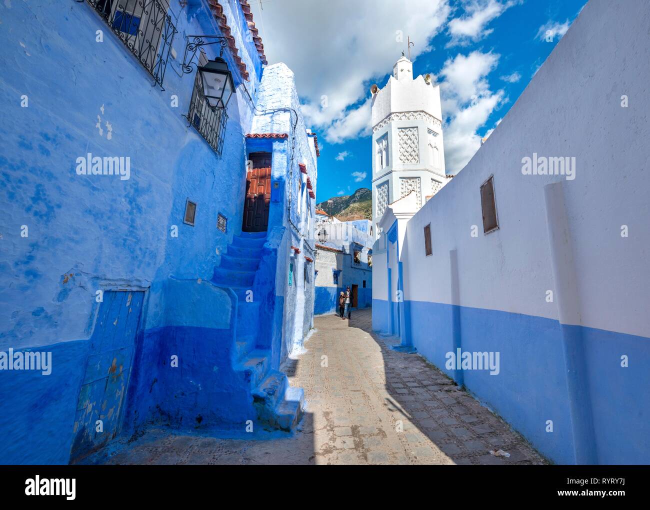 Minaret of a mosque, narrow lane between blue houses, Medina of Chefchaouen, Chaouen, Tanger-Tétouan, Morocco Stock Photo