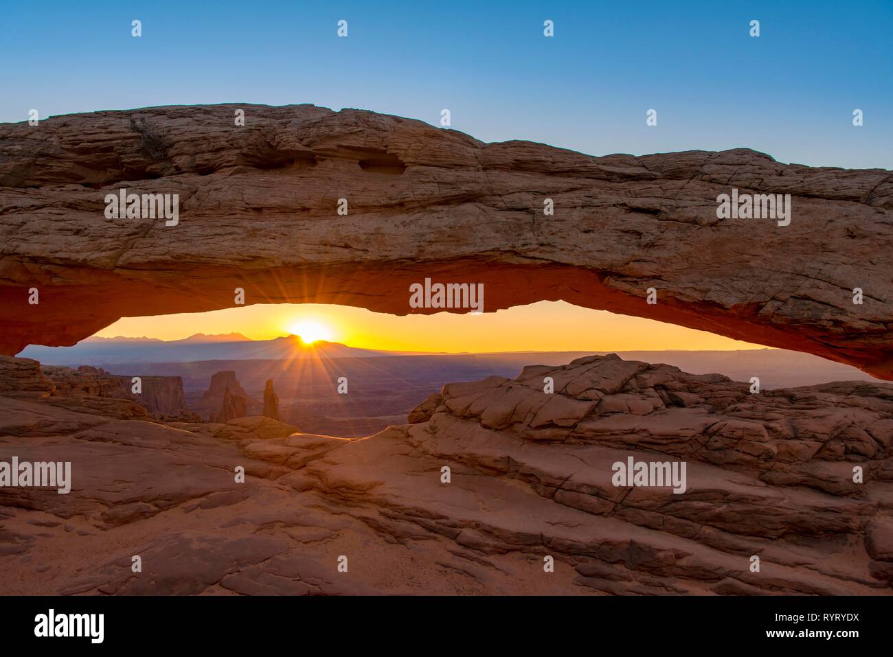 View through rock arch, Mesa Arch, first sunbeams, sunrise, Grand View Point Road, Island in the Sky, Canyonlands National Park Stock Photo