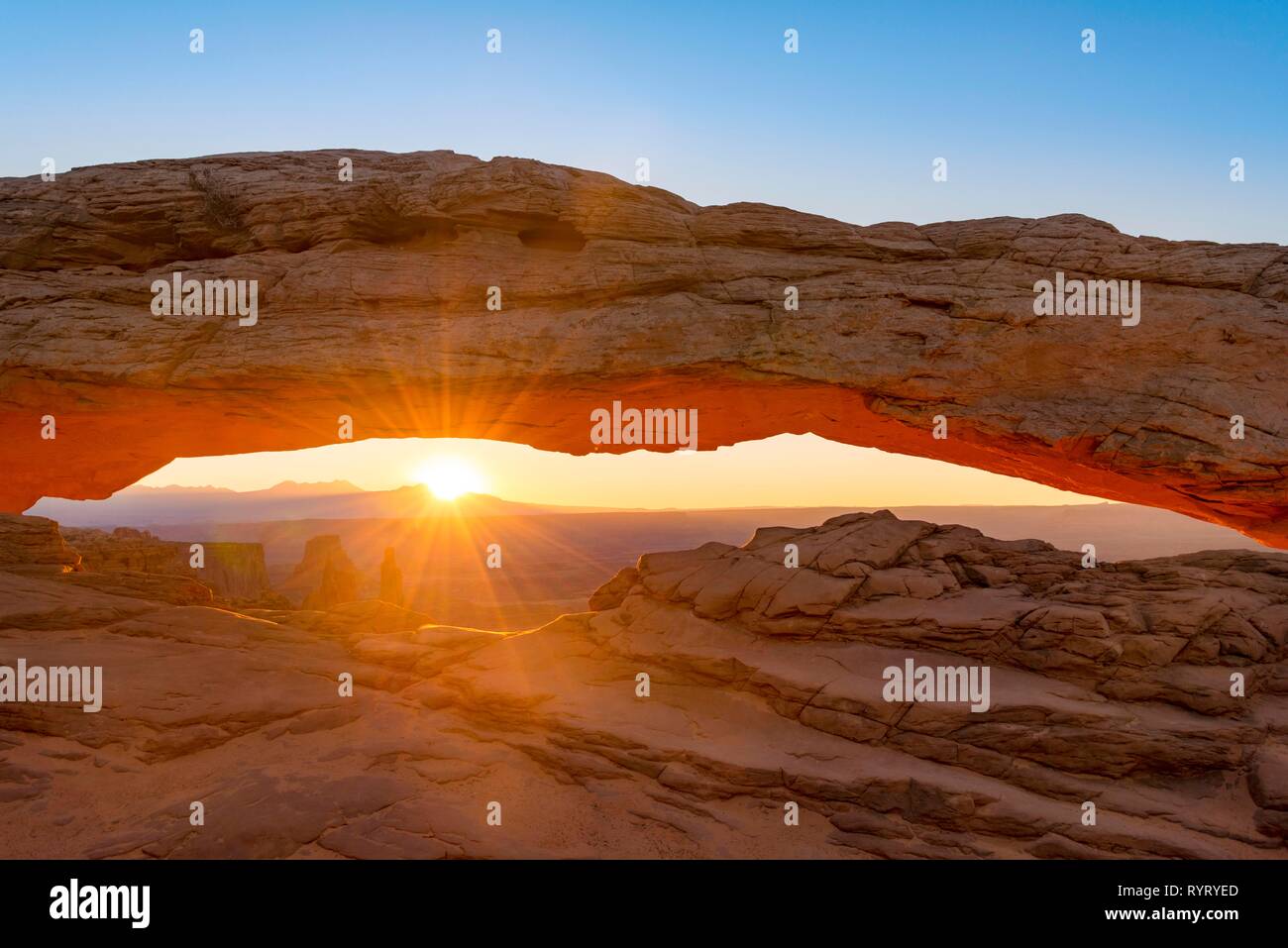 View through rock arch, Mesa Arch, sunbeams, sunrise, Grand View Point Road, Island in the Sky, Canyonlands National Park, Moab Stock Photo