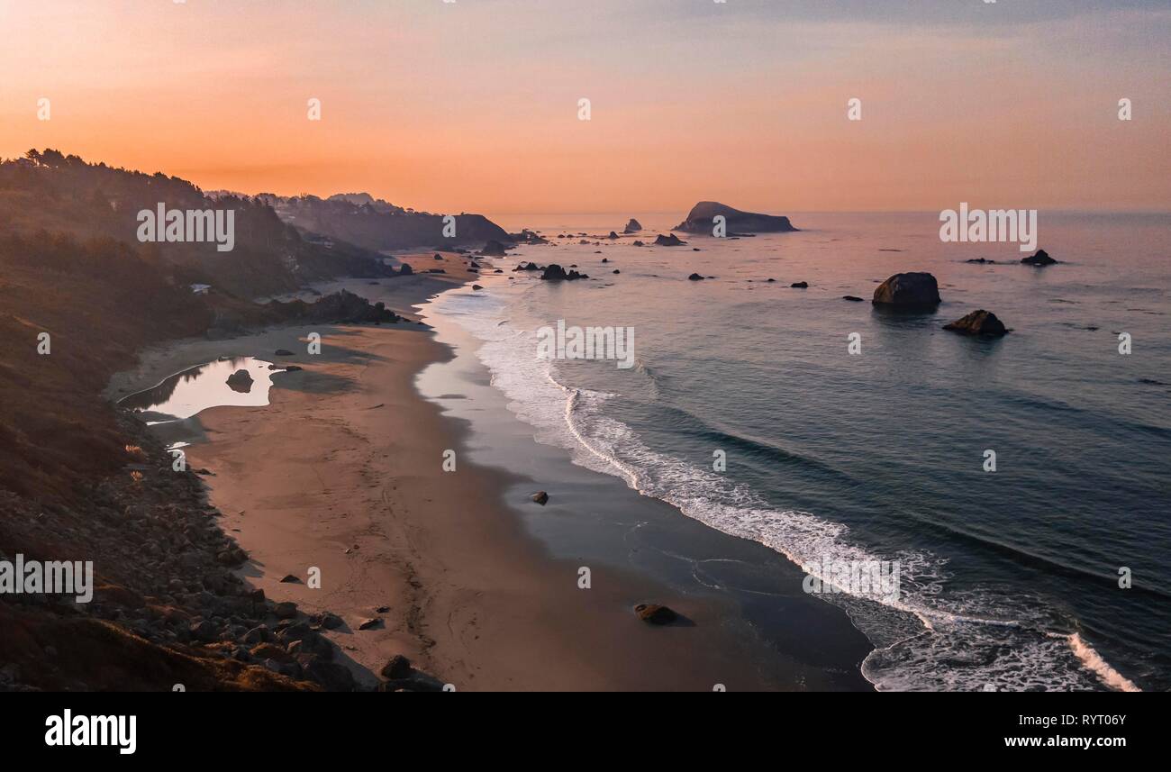 Sunrise, sandy beach, coastal landscape with many rugged rocky islands, Oregon, USA Stock Photo