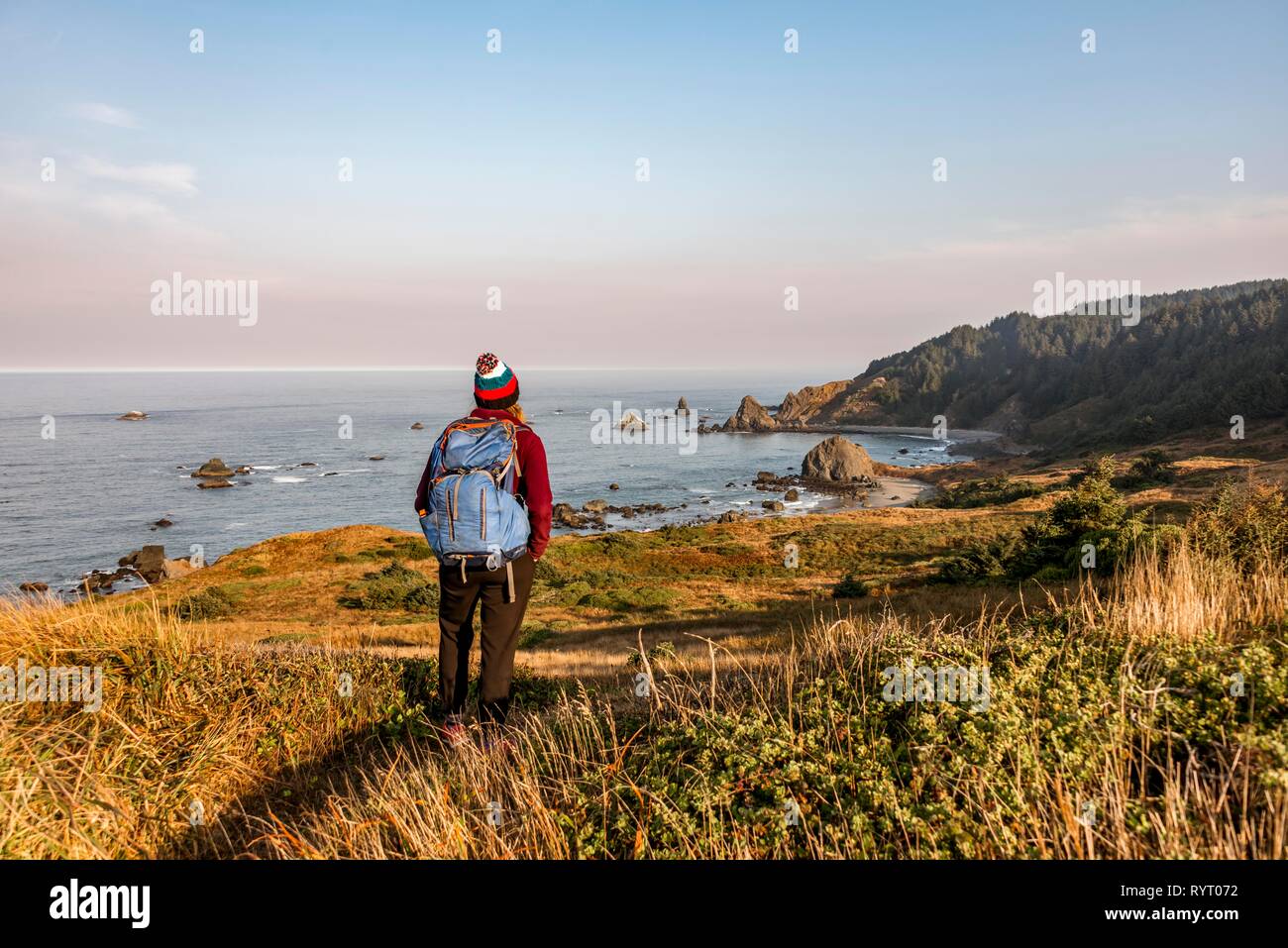 Young woman on a hiking trail along the rugged coast with many rocks, Whaleshead, Samuel H. Boardman State Scenic Corridor Stock Photo