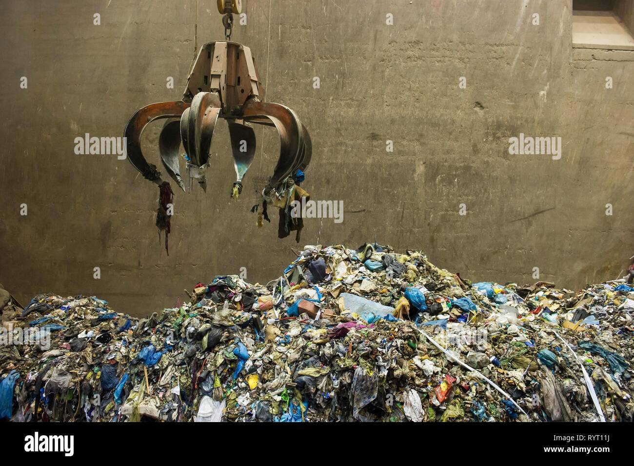 Gripper arm over pile of trash, crane transports waste in a waste incineration plant, TREA Breisgau, Eschbach Stock Photo