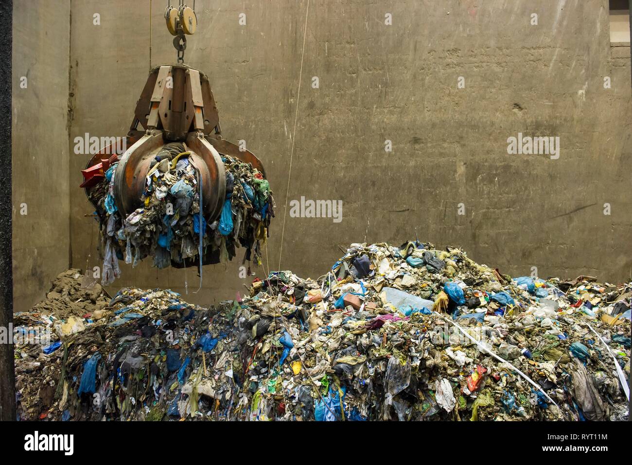 Gripper arm over pile of trash, crane transports waste in a waste incineration plant, TREA Breisgau, Eschbach Stock Photo