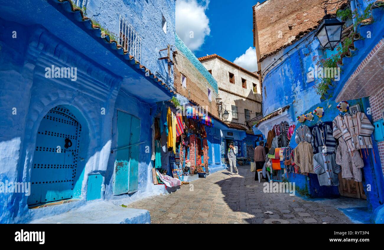 Narrow alley with shops, blue houses, medina of Chefchaouen, Chaouen, Tanger-Tétouan, Morocco Stock Photo
