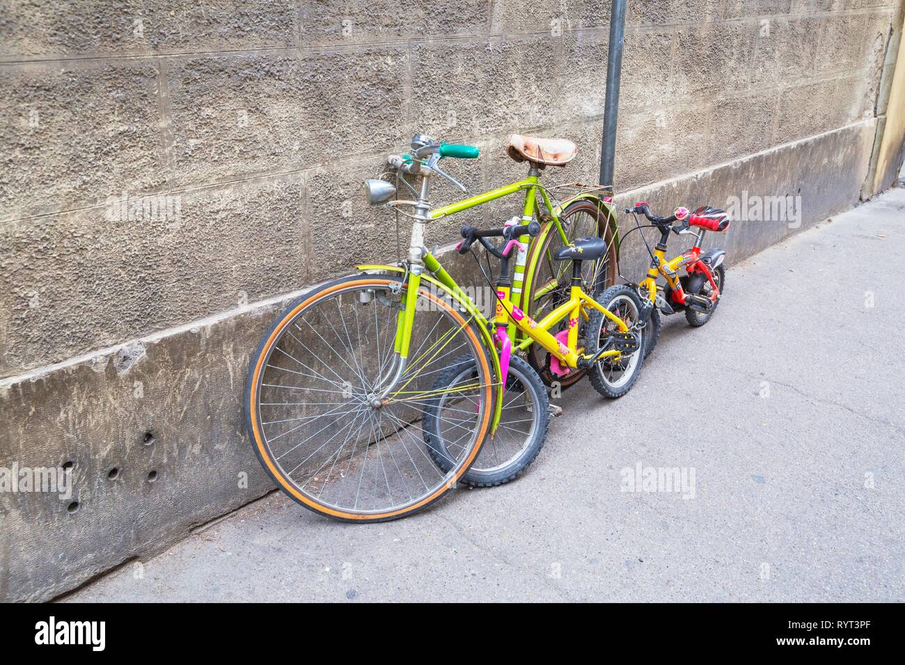 Bicycles for adult and children parked against wall, Florence, Tuscany, Italy Stock Photo