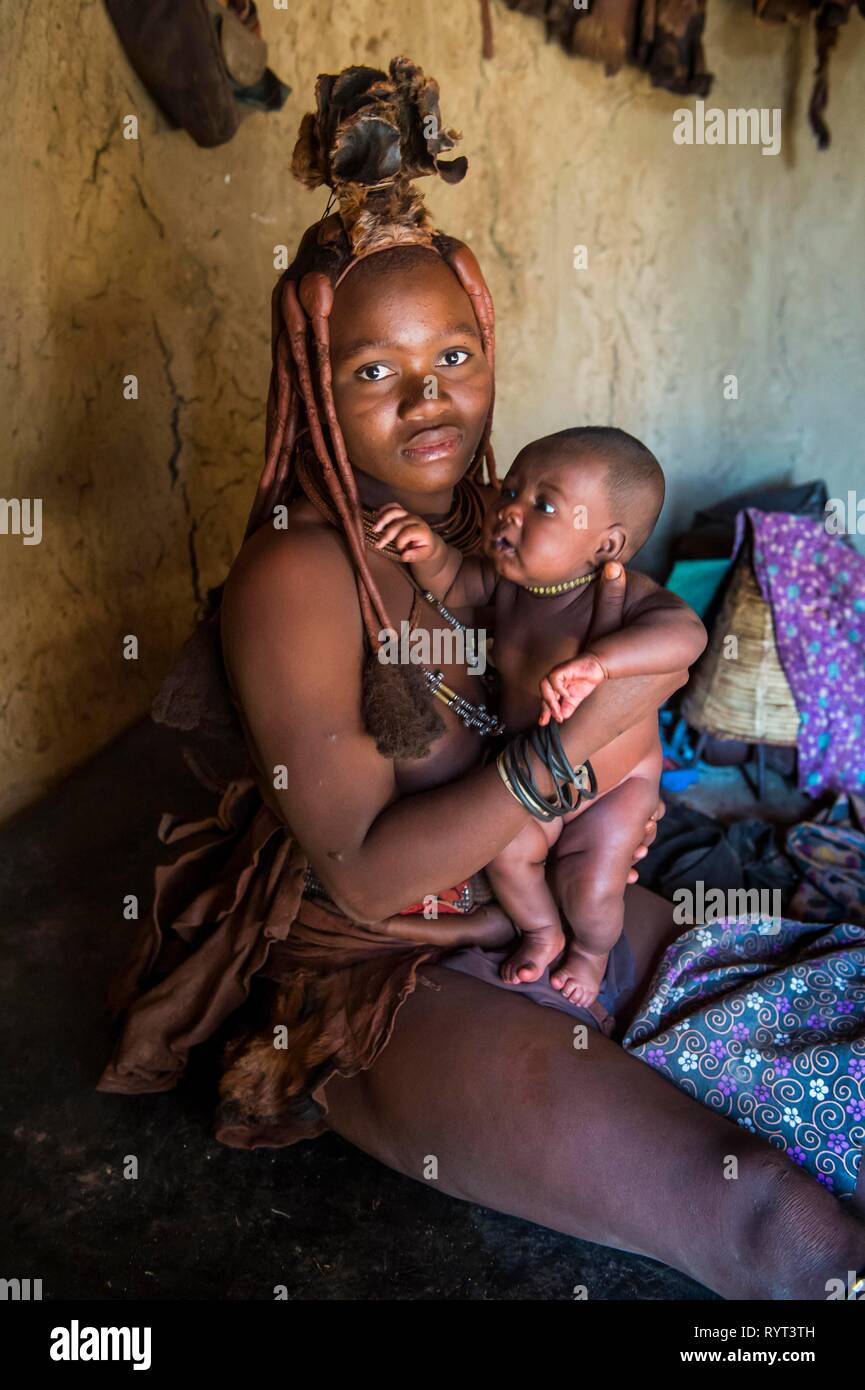 Himba woman holding her baby, Kaokoland, Namibia Stock Photo
