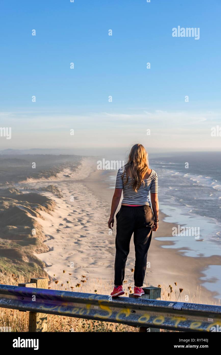 Young woman looking into the distance at a vantage point, view over Baker Beach, Oregon Coast Highway, Oregon, USA Stock Photo