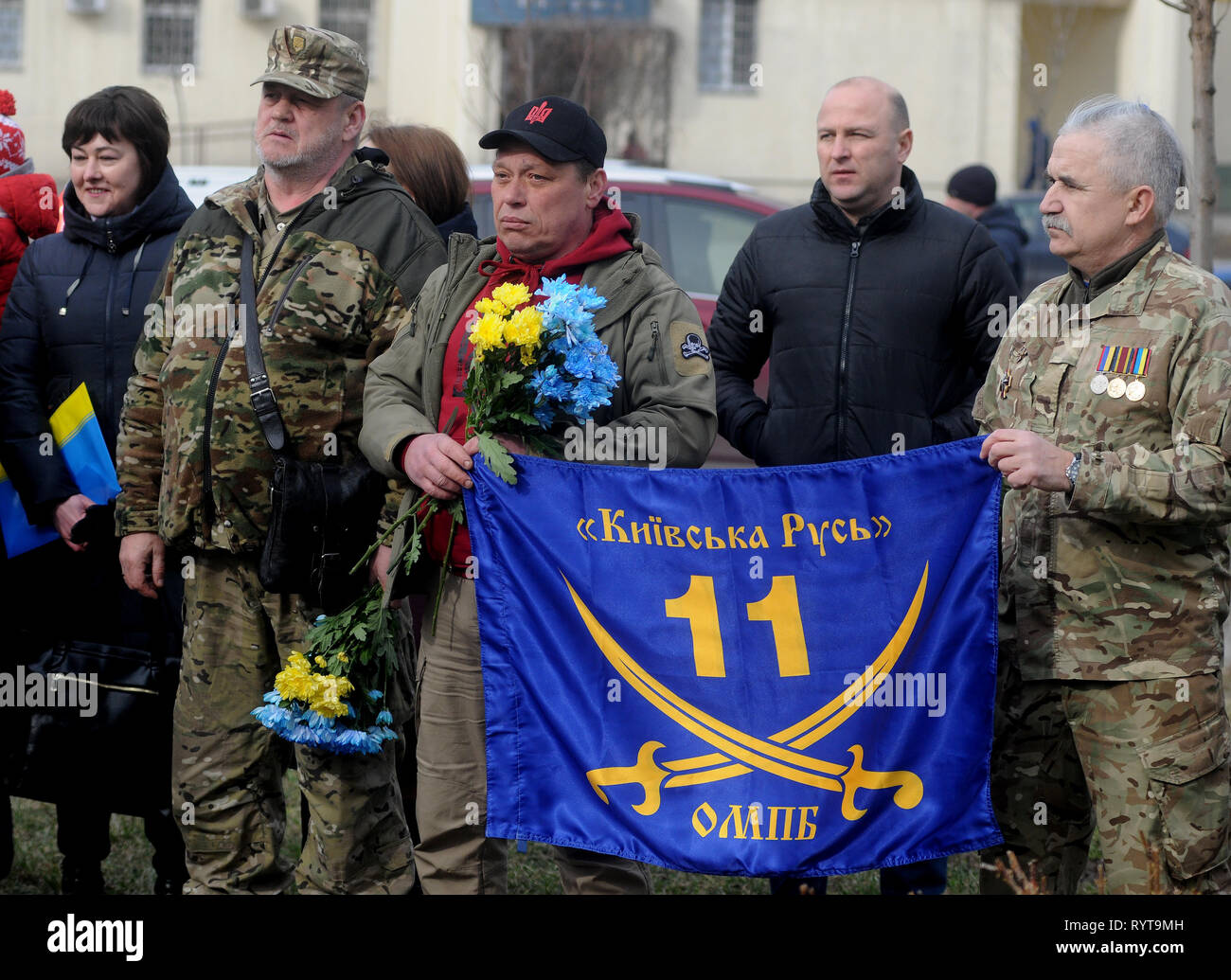 Volunteers are seen holding a flag of the 11th separate motorized infantry battalion 'Kievan Rus' during the celebrations to mark the Day of the Ukrainian Volunteer in Kiev. Ukraine celebrates Volunteer Day, which was founded in honor of citizens who voluntarily decided to protect the state from Russian aggression. It was on this day five years ago that the first 500 volunteers from the “Self-Defense of Maidan” social movement arrived at the Novye Petrivtsi training ground to form a volunteer battalion, which relocated to the Dnipropetrovsk region in early April 2014 and was named Dnipro-2. Th Stock Photo