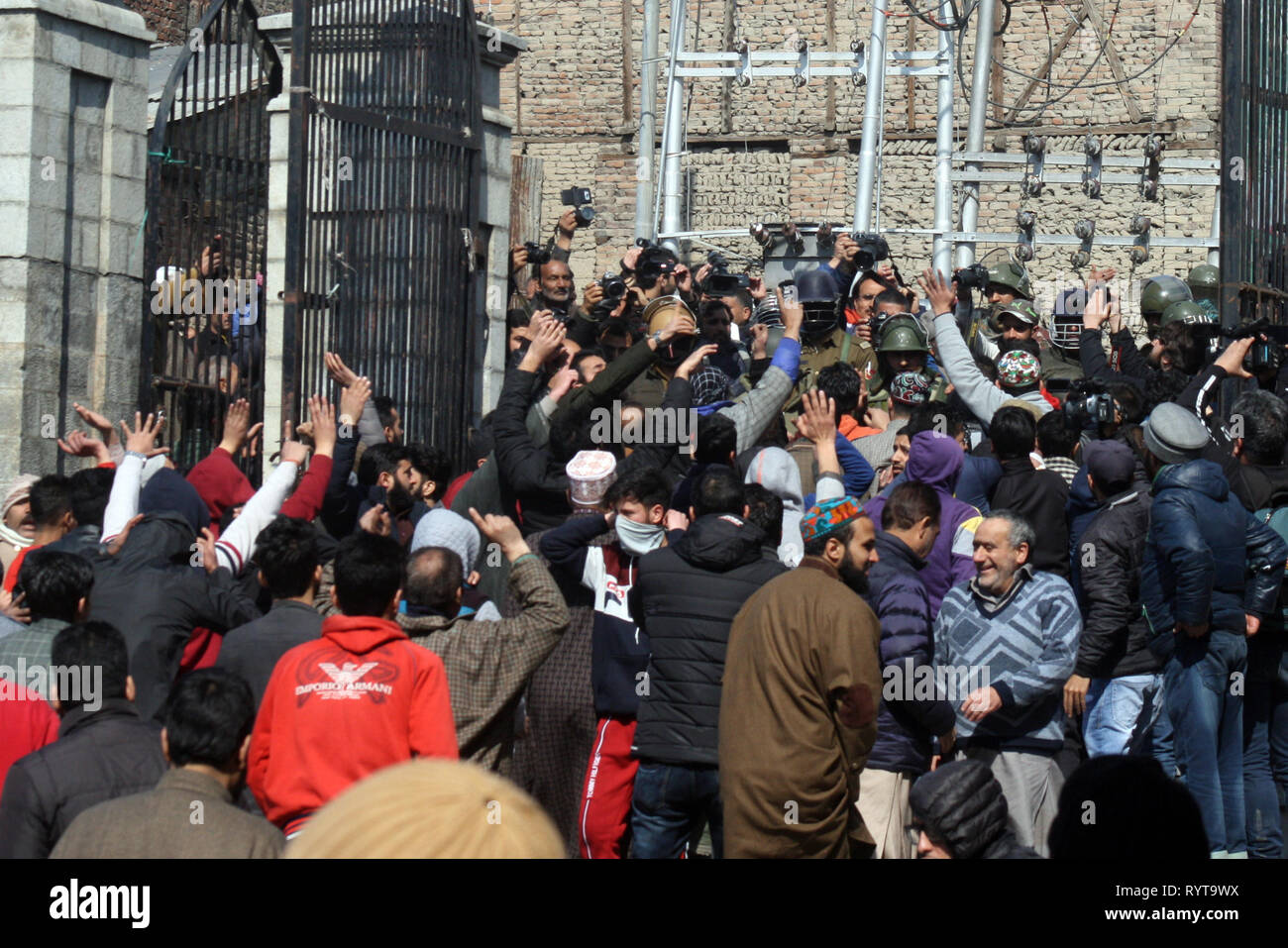 Srinagar, Kashmir. 15th March, 2019. Kashmiri protesters and worshippers shout slogans in the main gate of Grand Jamia Mosque as Indian police watching  ,during a protest against .National Investigation Agency (NIA) that summoned Senior separatist and religious leader Mirwaiz Umer Farooq to Delhi twice so far .and denounce the massacre of 49 people in two New Zealand mosques saying the brutality proved that there is no place terrorism cannot reach.©Sofi Suhail/Alamy Live News Stock Photo