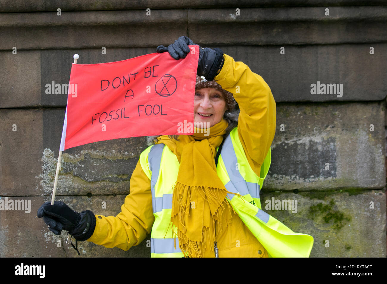 Preston, Lancashire. 15th March, 2019. Pauline waving a red flag 'Don't be a fossil fool' at the School strike 4 Climate change, as parents and school children assemble outside the railway station with banners and placards protesting for action against climate change.  The demonstrators marched through the city centre to continue their protest at the Flag Market in the city centre. Children from around Lancashire have walked out of classes today as part of an international Climate Strike. Credit:MWI/AlamyLiveNews Stock Photo