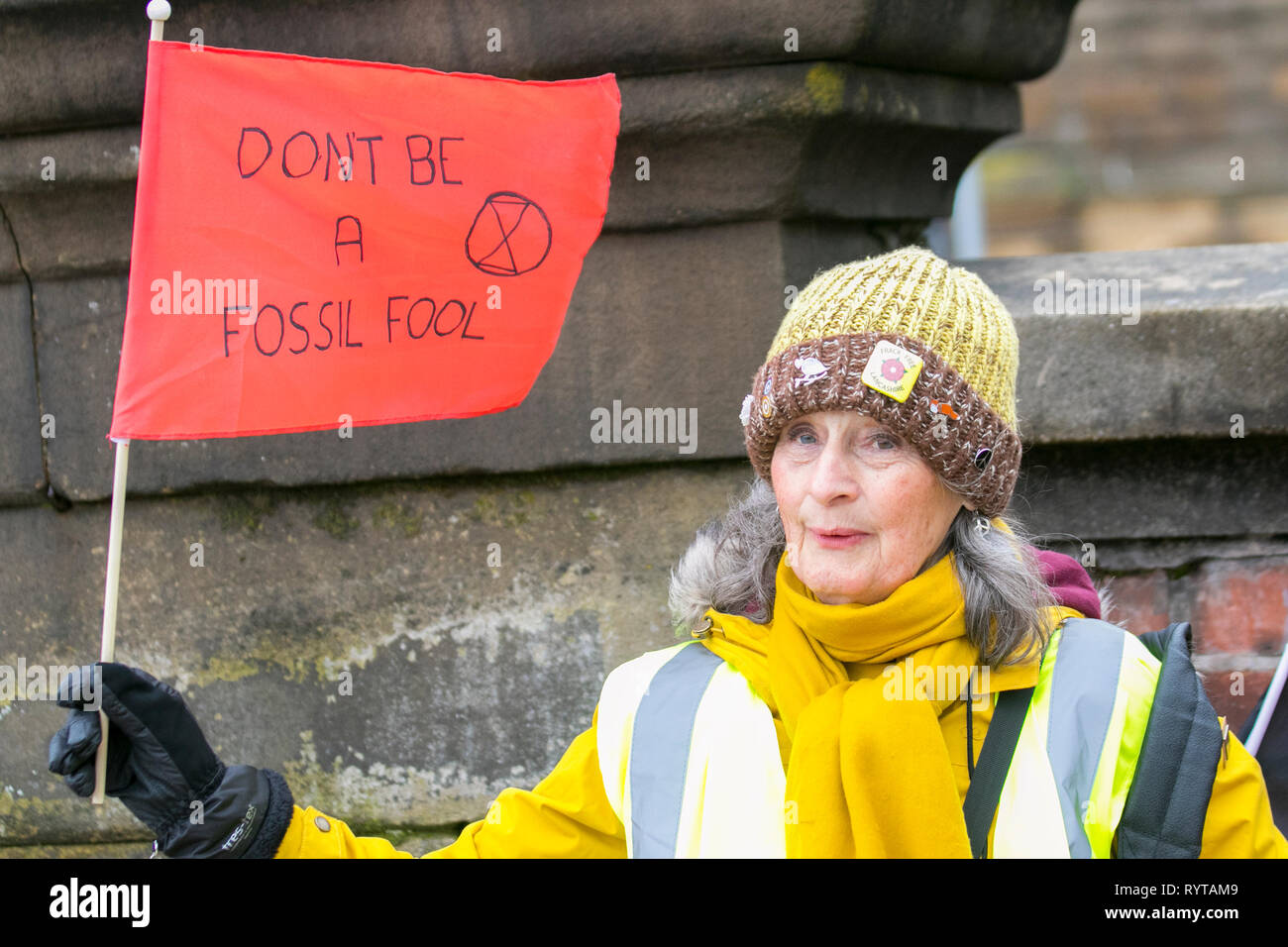 Preston, Lancashire. 15th March, 2019. Pauline waving a red flag 'Don't be a fossil fool' at the School strike 4 Climate change, as parents and school children assemble outside the railway station with banners and placards protesting for action against climate change.  The demonstrators marched through the city centre to continue their protest at the Flag Market in the city centre. Children from around Lancashire have walked out of classes today as part of an international Climate Strike. Credit:MWI/AlamyLiveNews Stock Photo