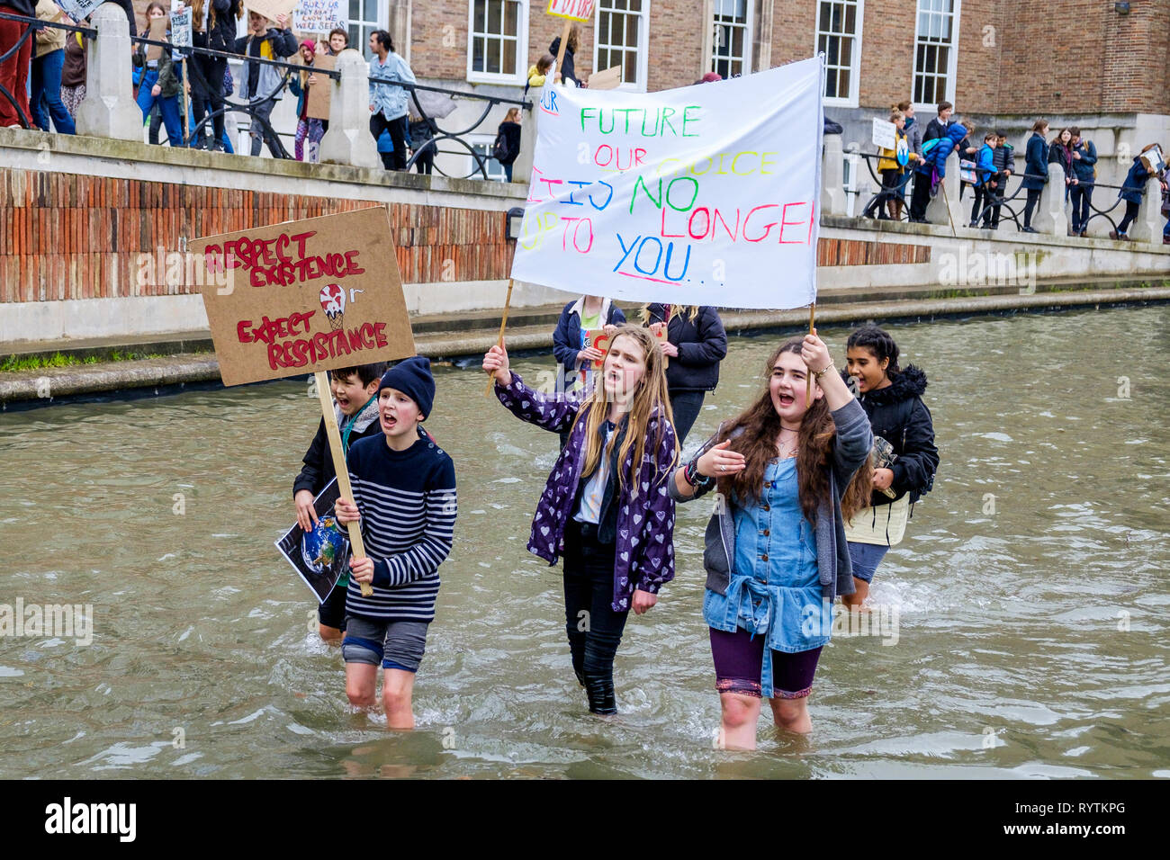 Bristol, UK. 15th March, 2019. Bristol college students and school children carrying climate change placards and signs are pictured standing in the moat outside Bristol City Hall as they protest against Climate change. The pupils who also went on strike last month walked out of school again today as part of a countrywide coordinated strike action to force action on climate change policy. Credit: lynchpics/Alamy Live News Stock Photo