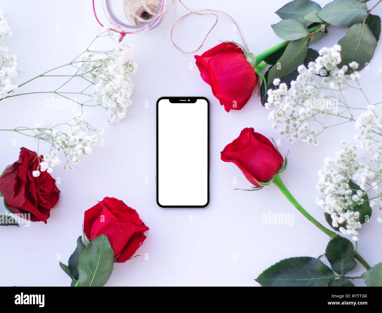 Mobile on a table with red roses Stock Photo - Alamy