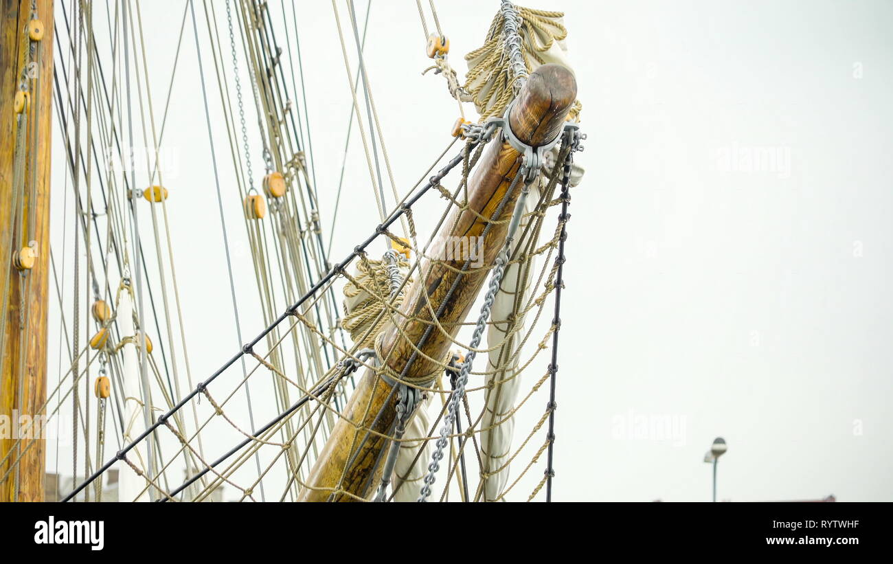 The front part of the big vessel ship docking on the port there are lots of ropes webbed ropes and chains on it Stock Photo