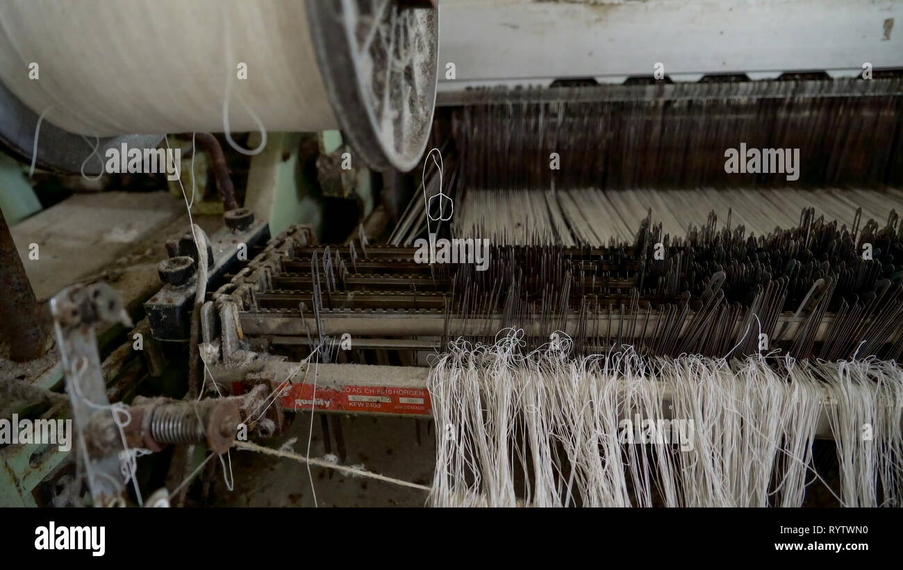 Old white threads from the old sewing machine inside the old textile
