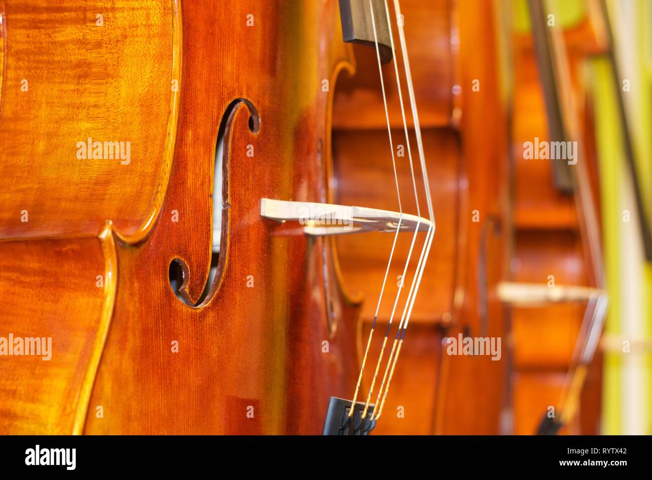 Cellos standing vertically one beside another Stock Photo