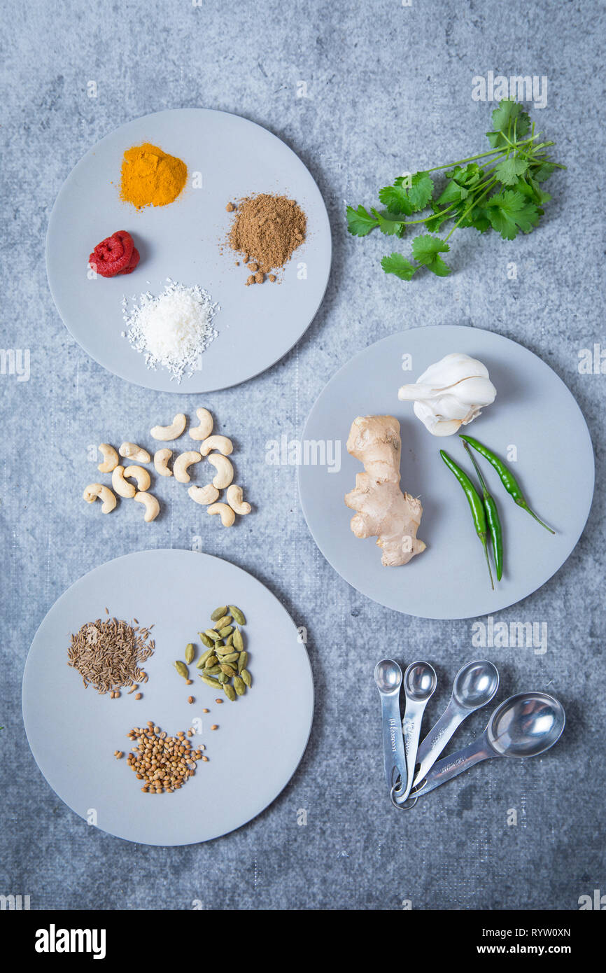 Ingredients for curry paste on round plates and a grey background