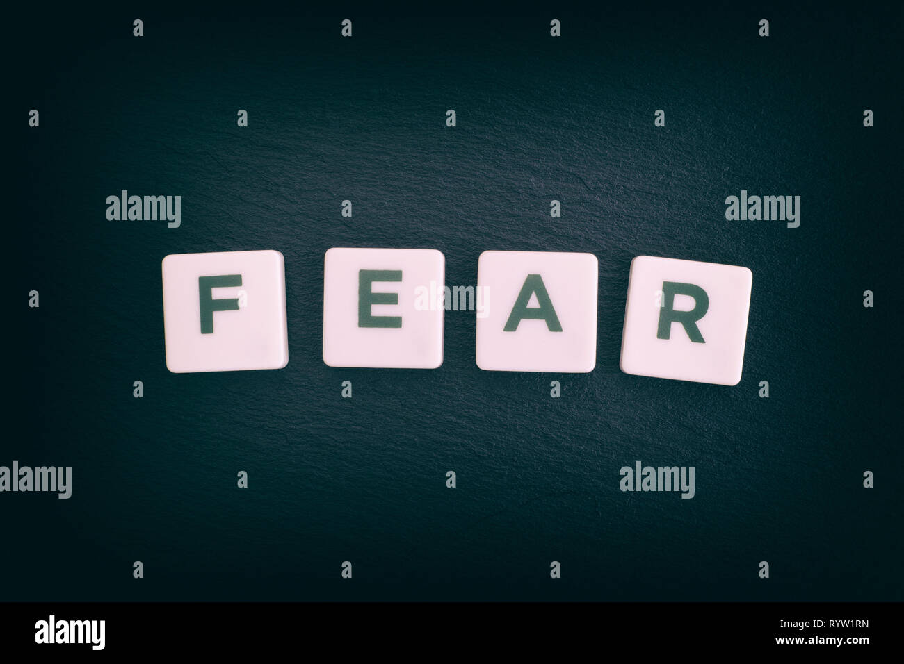 Word Fear on a black slate background. Close up. Stock Photo