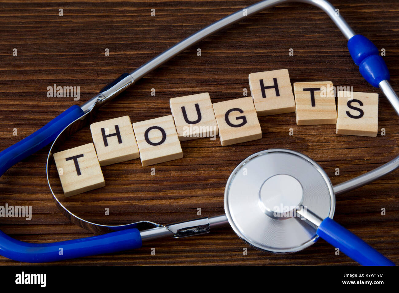 'Thoughts' word written on wooden blocks between stethoscope Stock Photo