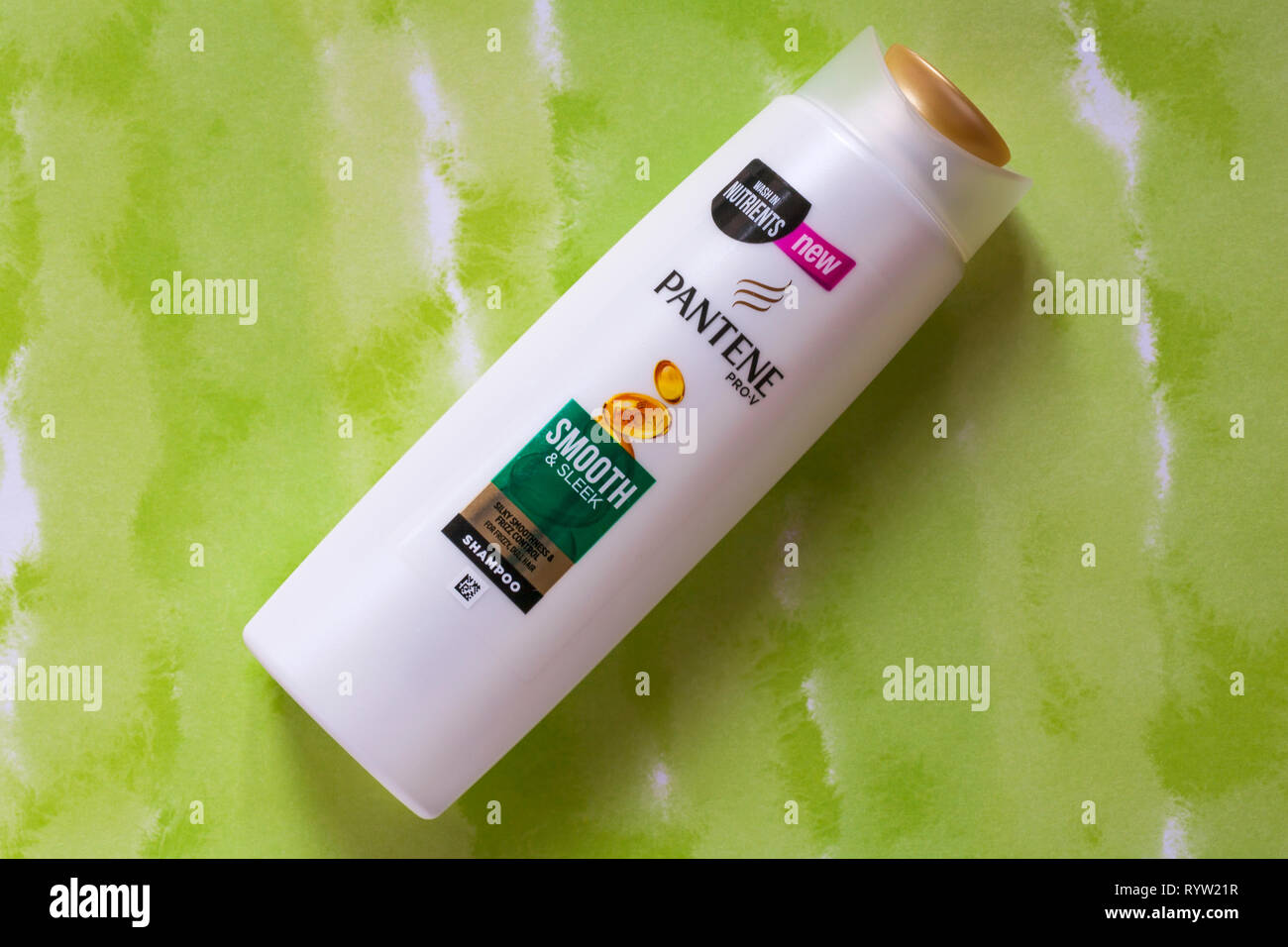 bottle of Pantene pro-v smooth & sleek shampoo on patterned background - silky smoothness & frizz control for frizzy dull hair Stock Photo