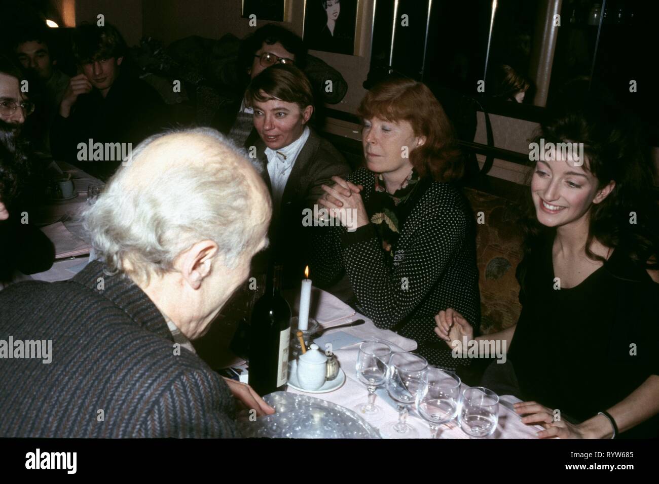 Dinner during the shooting of the film 'Les Nuits de la pleine lune' by Eric Rohmer. Foreground: Eric Rohmer In the background, from left to right: French producer of Les Films du Losange Margaret Menegoz, Aurore Clément and Pascale Ogier. 1984 Stock Photo