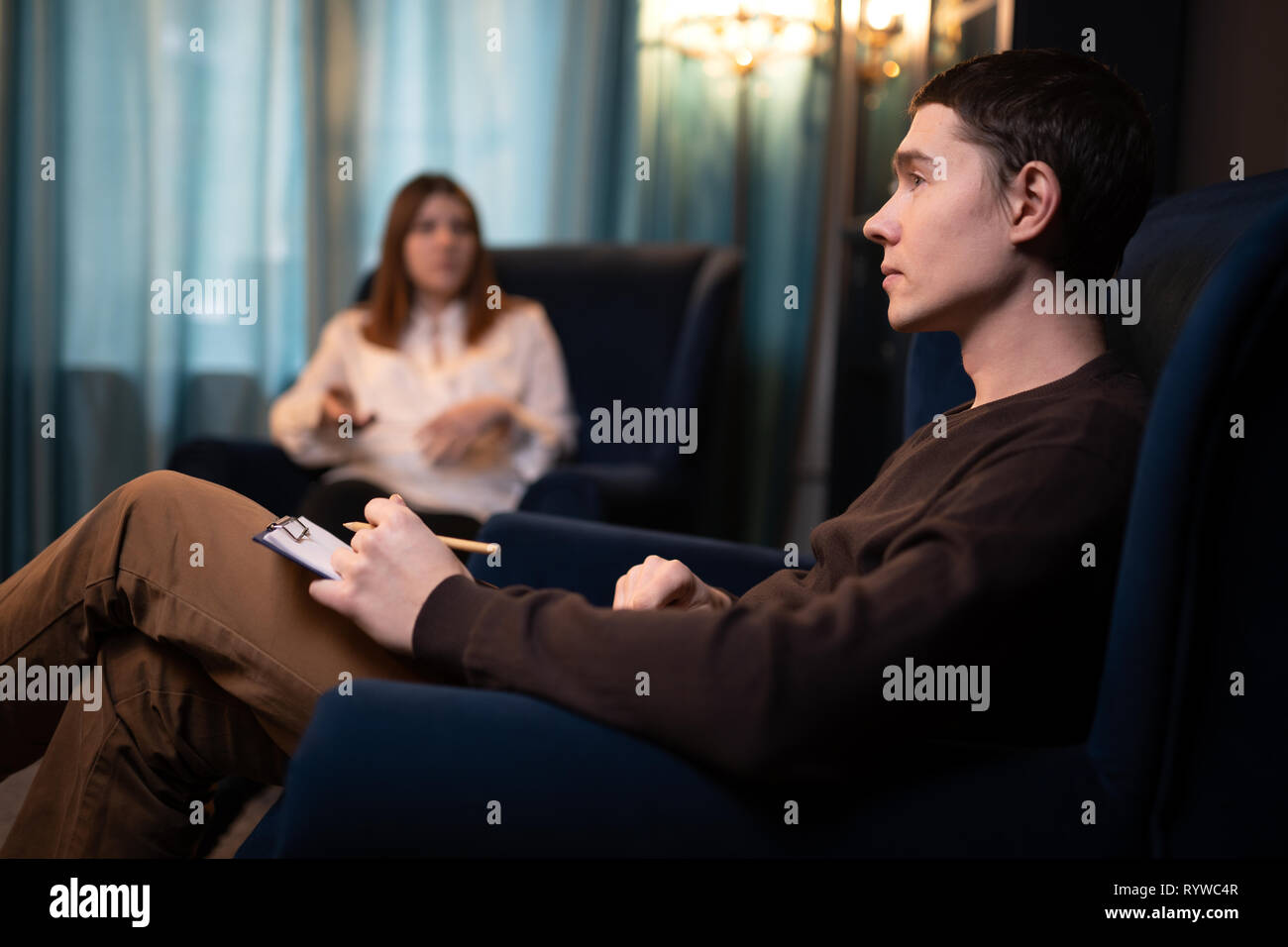 Photo at side of man psychologist and woman at consultation in office. Stock Photo