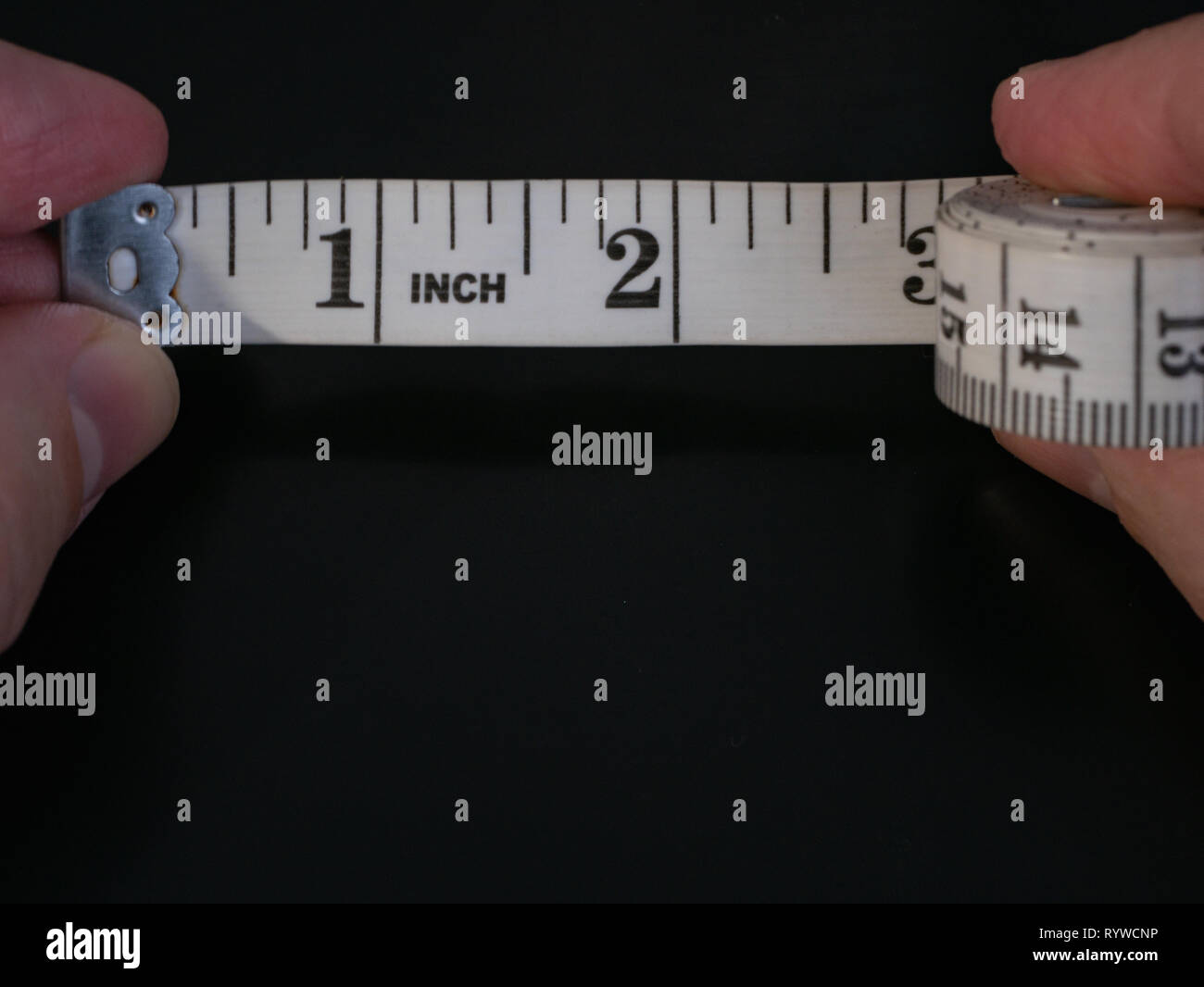 pix How To Measure Inches With Fingers https www alamy com macro extreme close up of man fingers holding measure tape ruler with few inches unrolled on dark black background image240889314 html