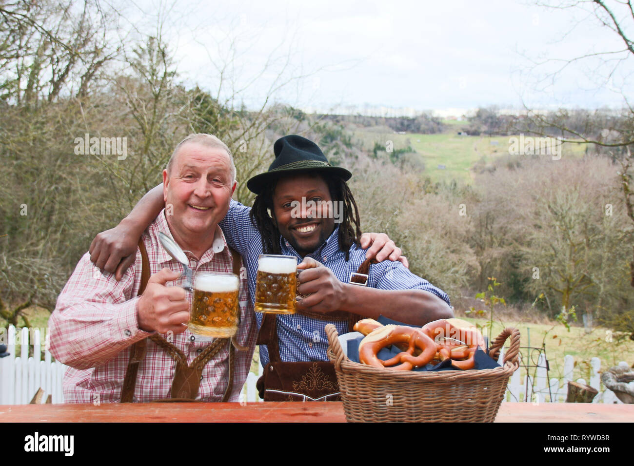 Two men wearing Bavarian October festival strive, drinking beer and feeling happy outdoors Stock Photo