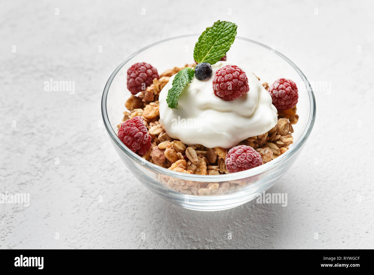 Granola, yougurt and raspberries in bowl Stock Photo