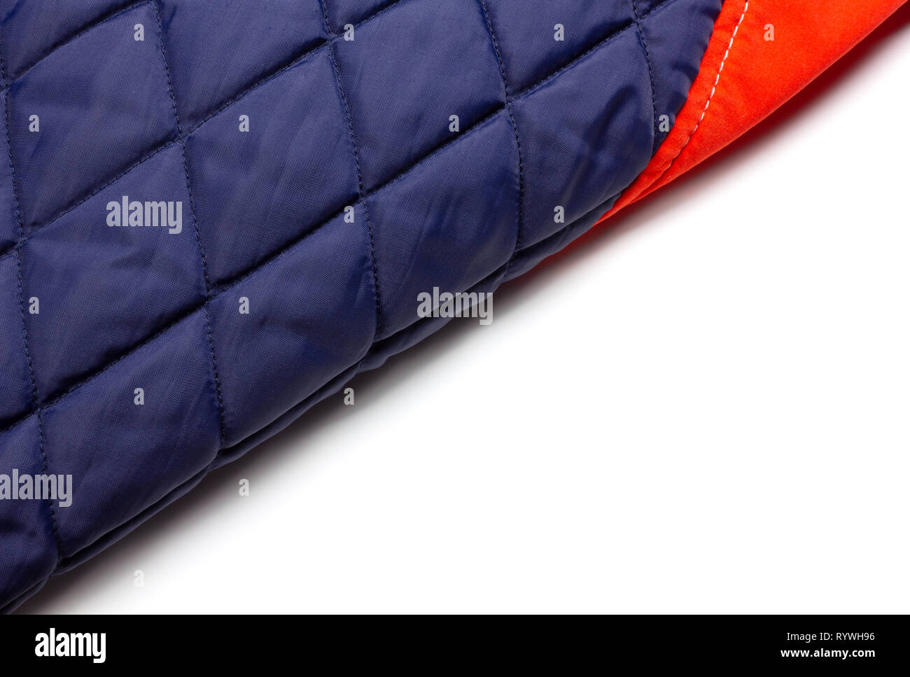 Detail of a portion of the inner side of a red and blue down jacket on a white background, placed so as to divide the composition in two diagonally Stock Photo