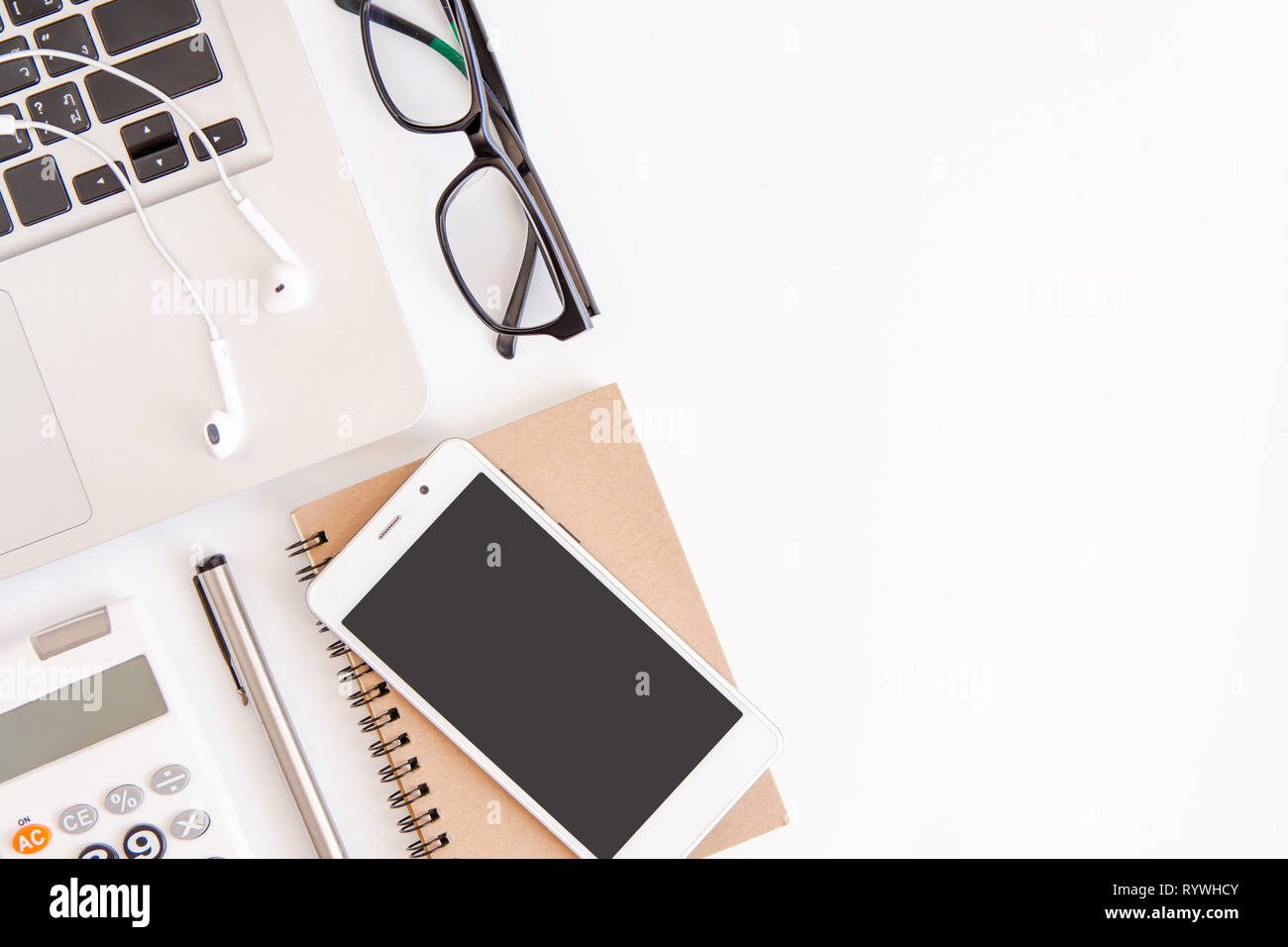 White office desk table, workspace office with laptop, smartphone black screen,pen,calculator, glasses, Top view with copy space Stock Photo