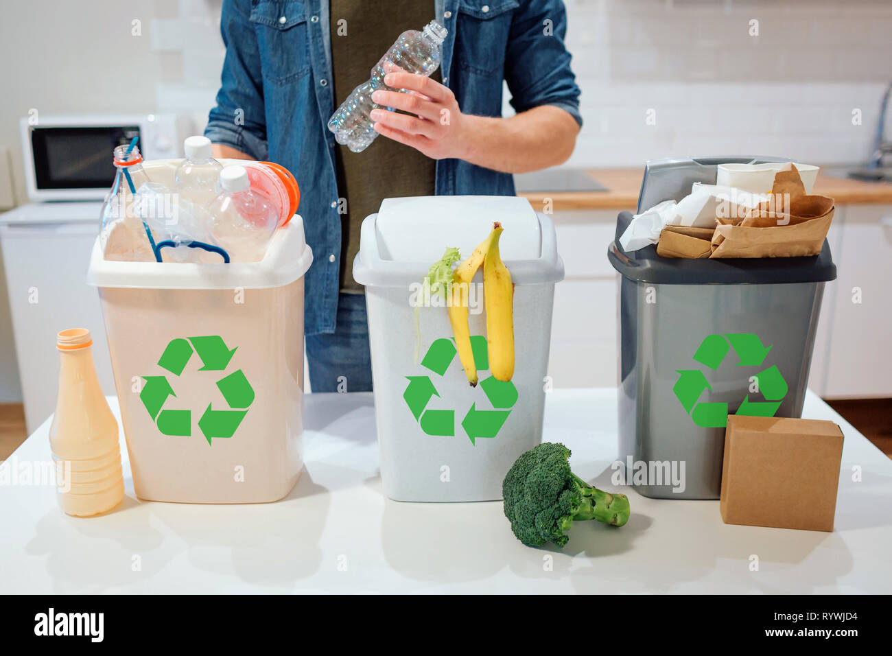 Waste sorting at home. Recycling. Man putting plastic bottle in the