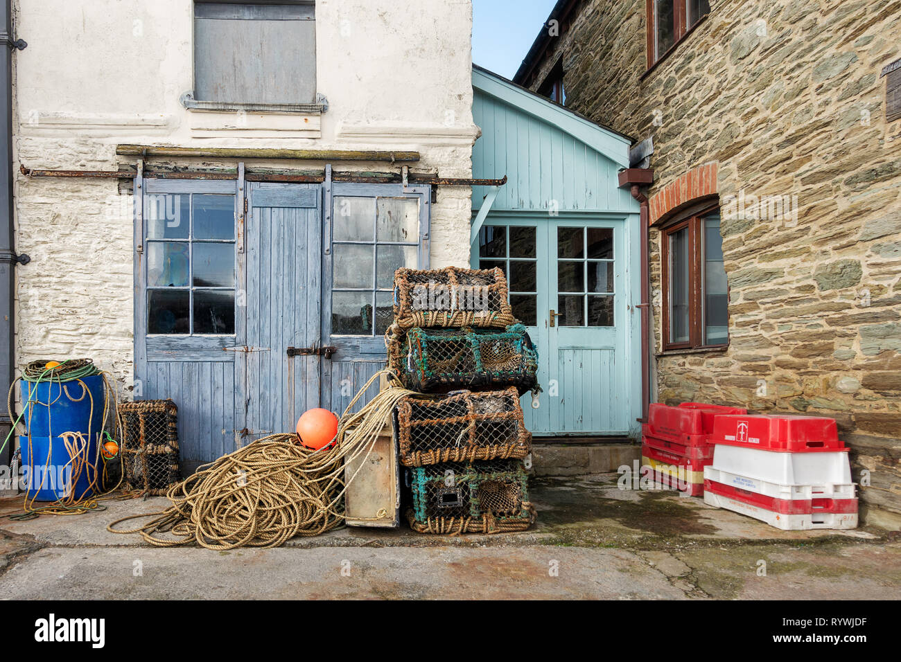 A fisherman's shed on the quayside at Salcolmbe, Devon. There are crab pots, ropes, floats and fish boxes outside the shed. Stock Photo