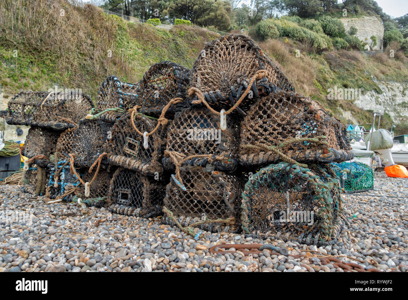 Crab traps sit on the shingle beach at Beer, Devon. Stock Photo