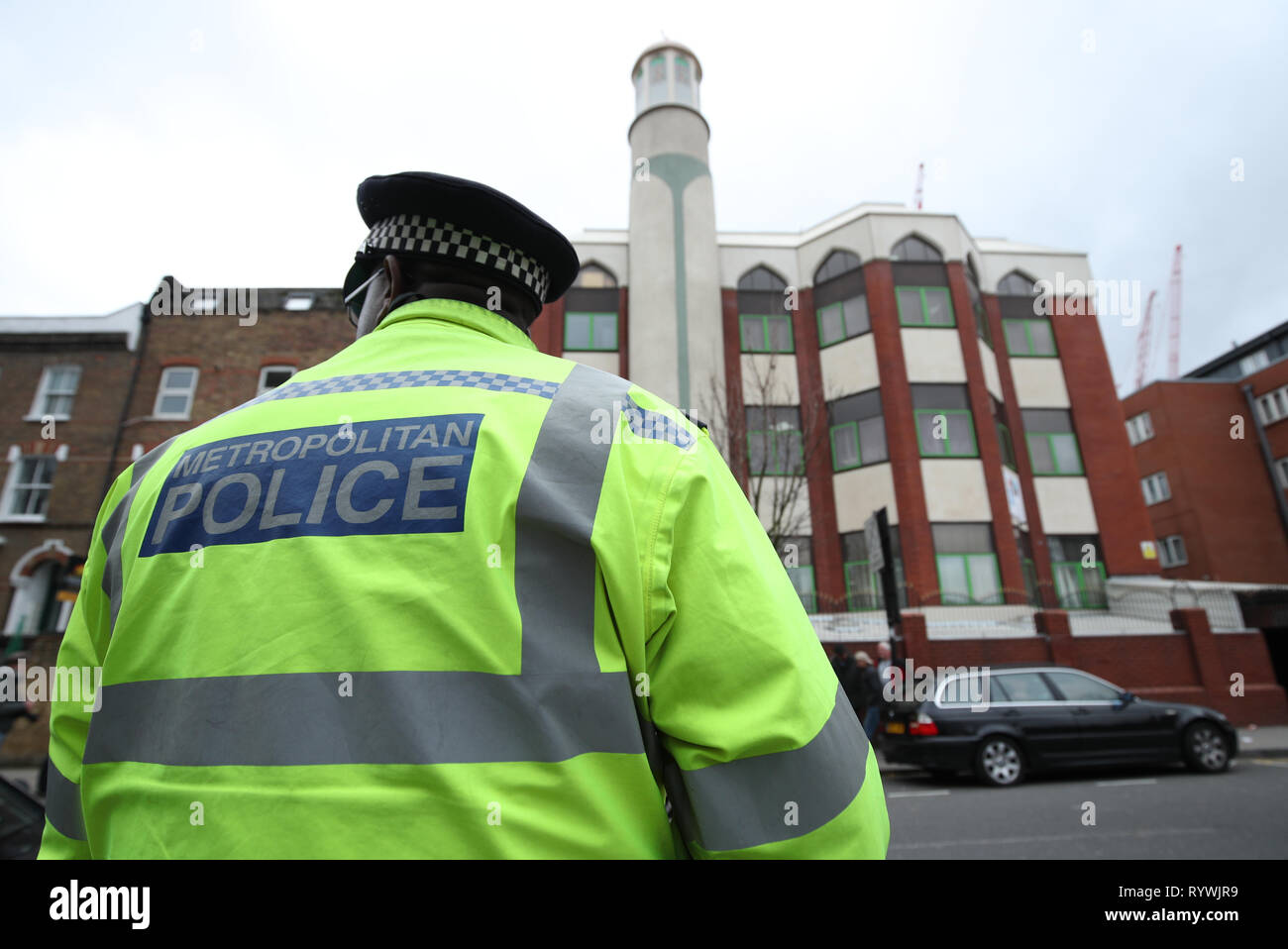 A police officer stands opposite Finsbury Park Mosque in London, ahead of the Friday prayer service, following the Christchurch mosque attacks in New Zealand. Stock Photo