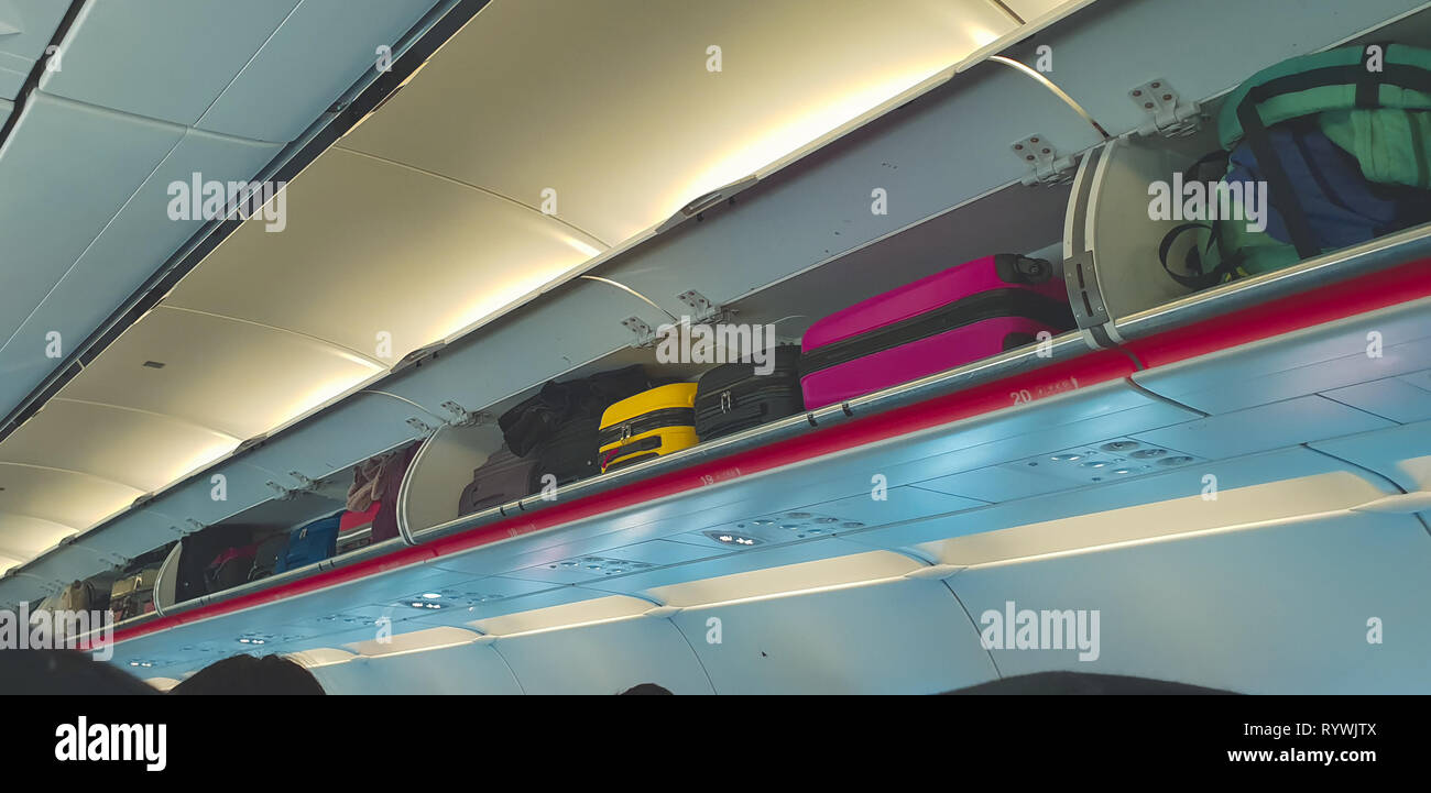 Carryon luggage on the top shelf over head on airplane Stock Photo Alamy
