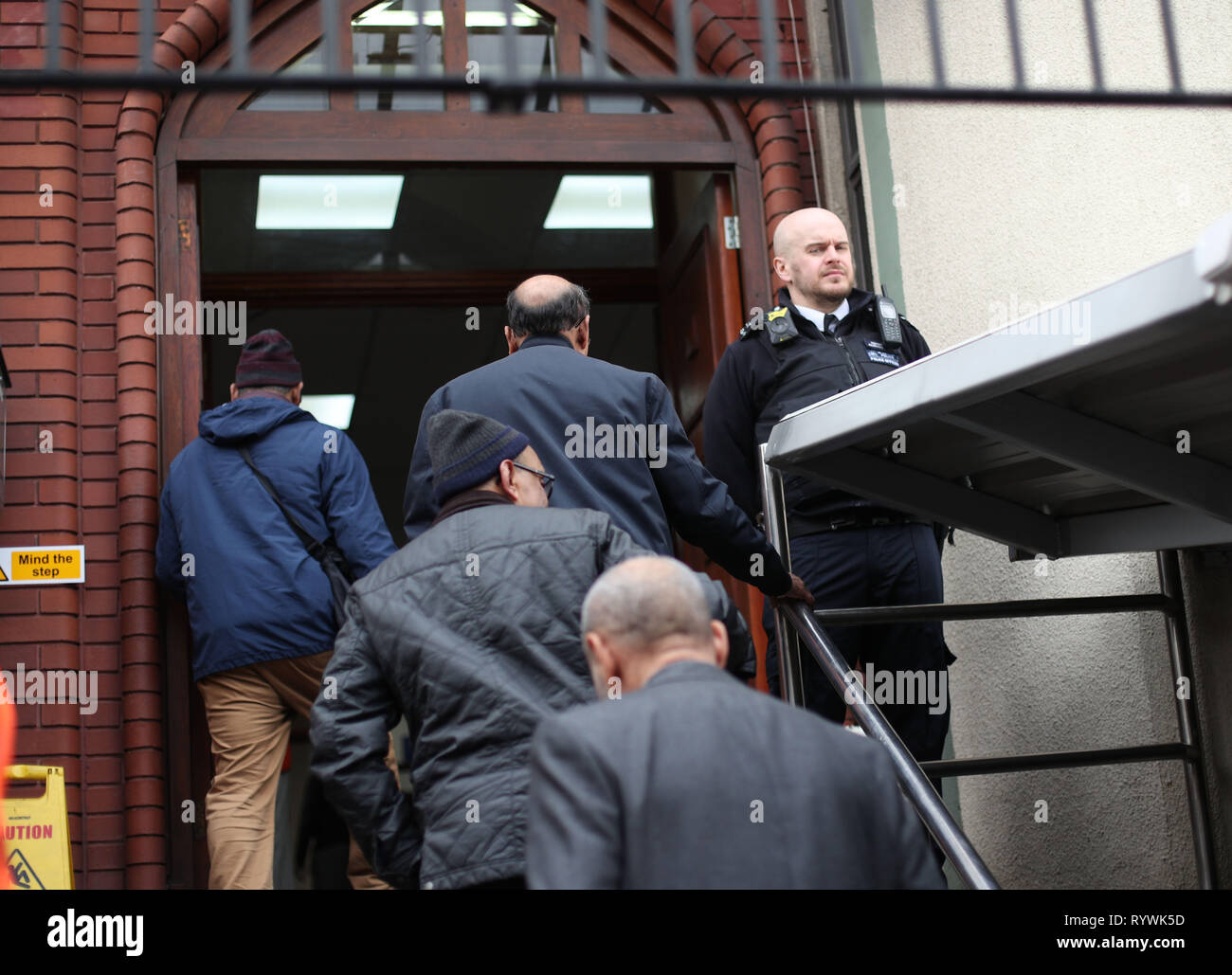A police officer stands outside Finsbury Park Mosque in London, following the Christchurch mosque attacks in New Zealand, as worshipers begin to arrive for the Friday prayer service. Stock Photo