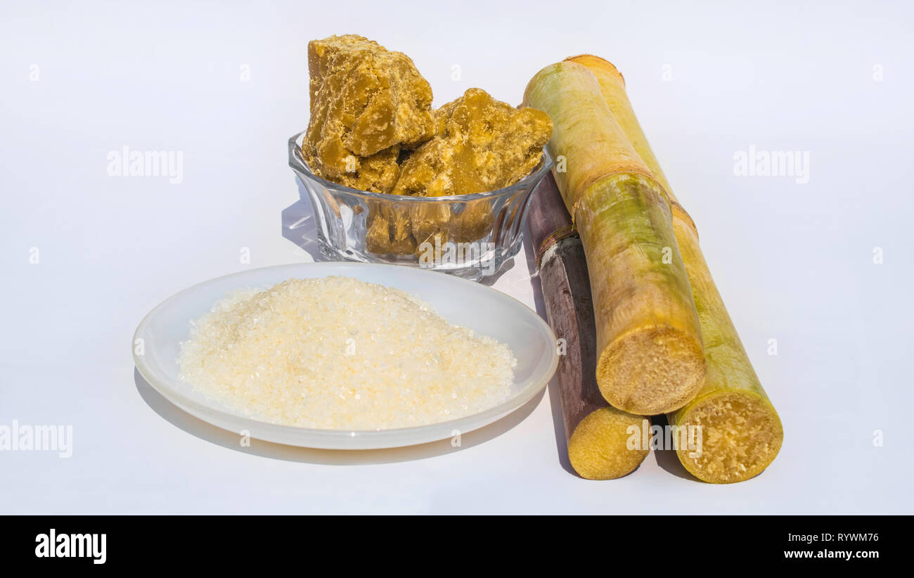 pieces of sugarcane with white sugar and brown sugar,isolated. Stock Photo