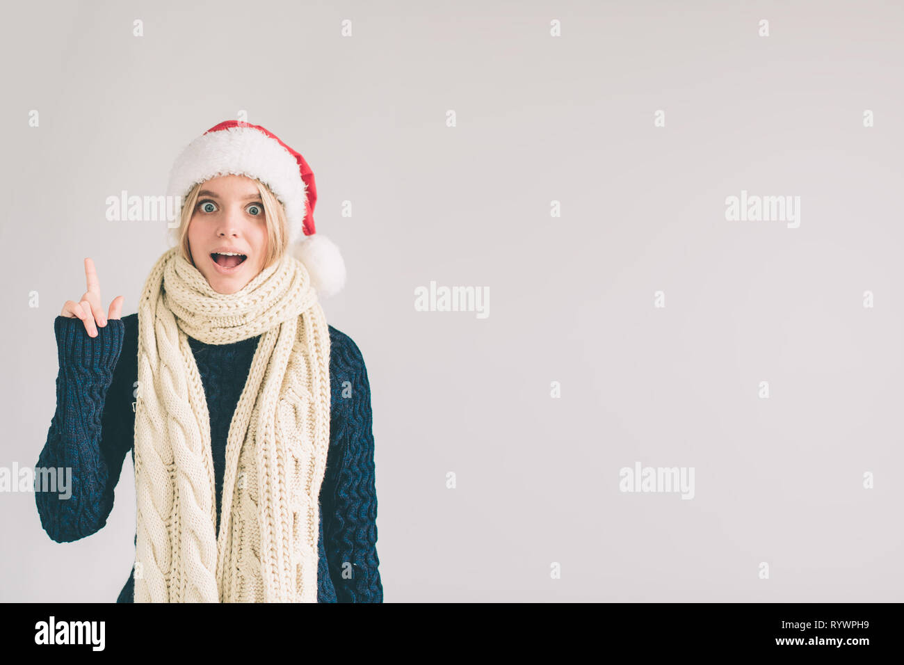 Young smiling woman having a good idea. Portrait of an excited female model pointing finger up at copyspace isolated on a white background. The girl i Stock Photo