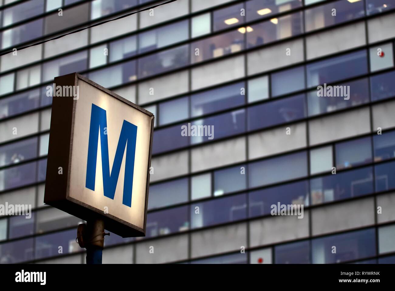 Bucharest, Romania - November 06, 2018: The symbol of a subway station is seen in front of a large office building in Bucharest, Romania. This image i Stock Photo