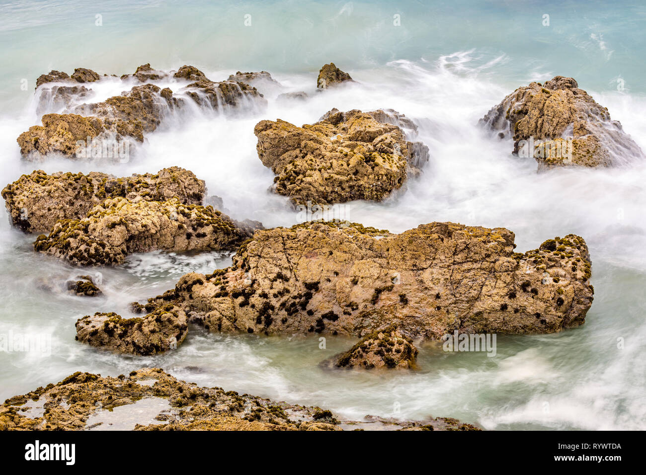 Gentle flowing water flowing around ocean rocks, Pacific ocean Northland, New Zealand Stock Photo